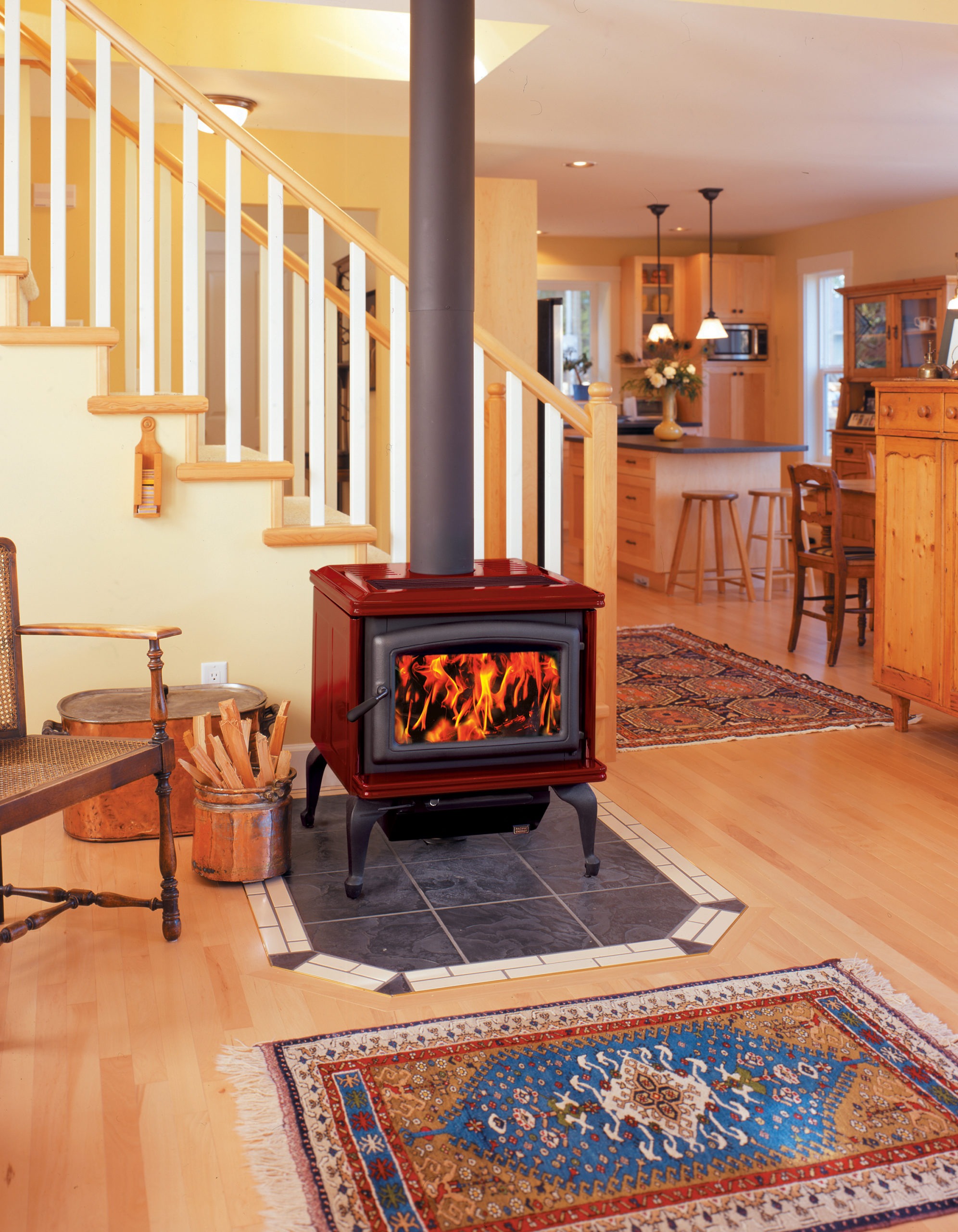 Summit Classic LE wood stove with Sunset Red porcelain enamel panels, metallic black legs, doors and trivet